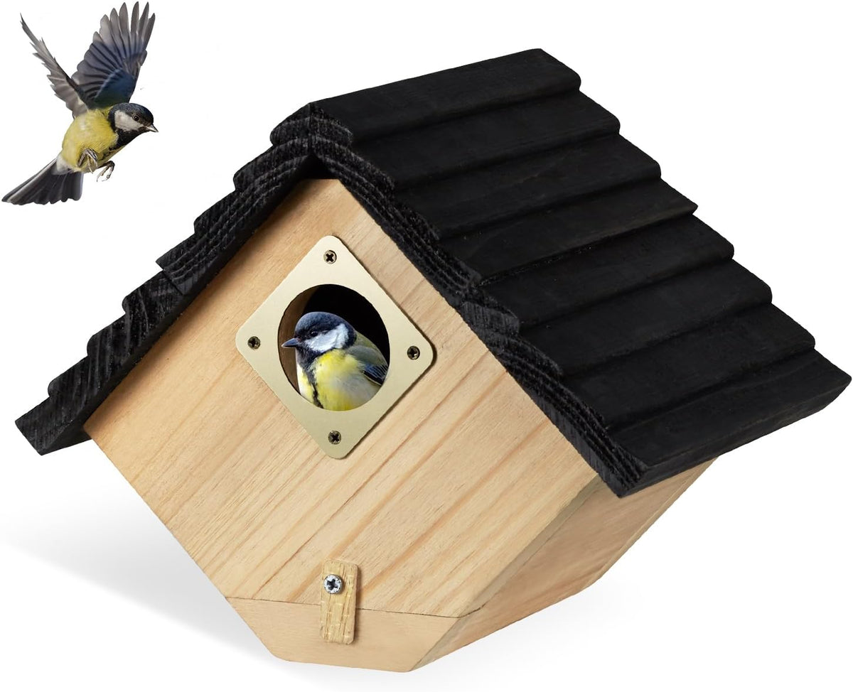 Wooden bird house with black shingled roof and bird at round entrance hole