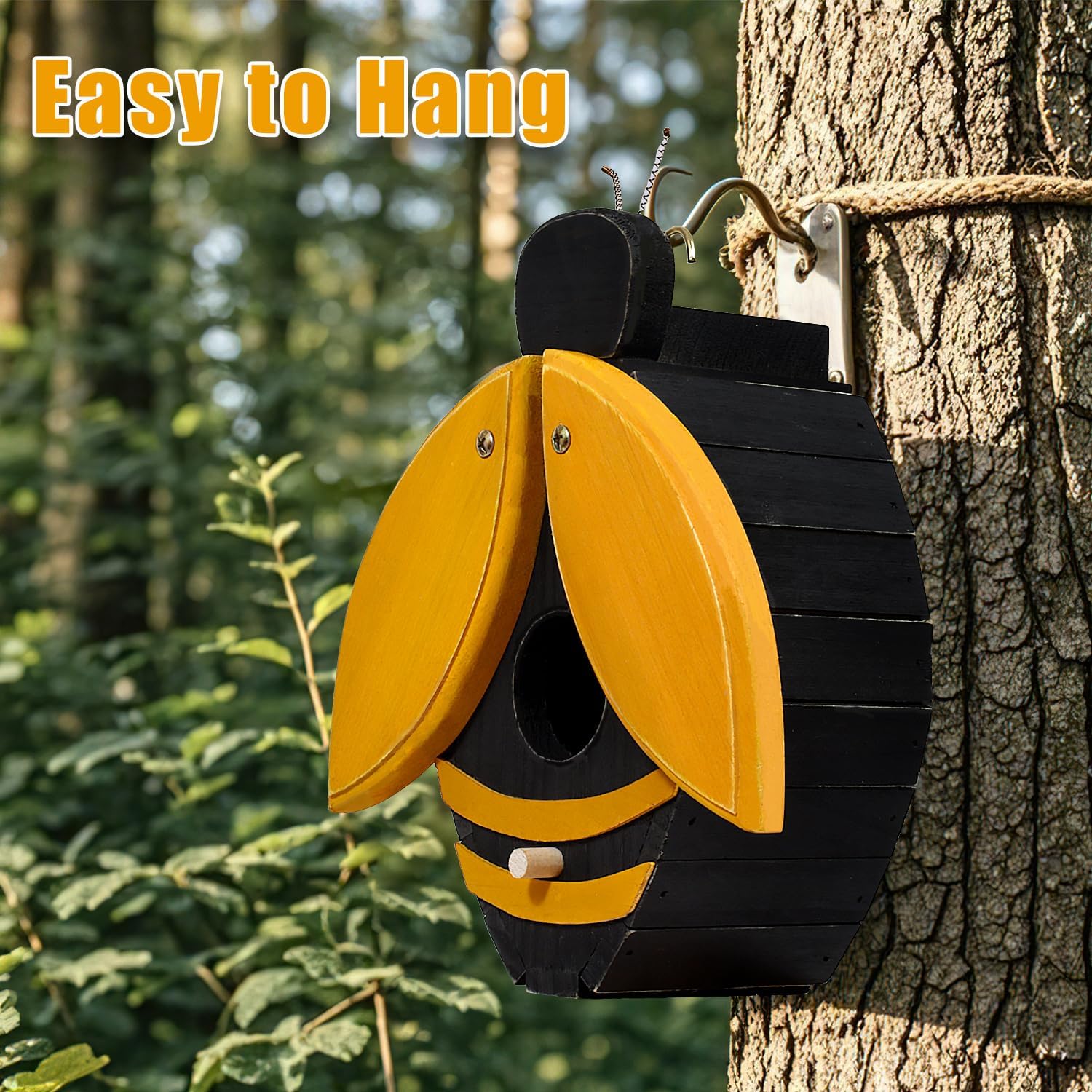 Bee-shaped wooden birdhouse with open yellow wings and black body, hanging on tree