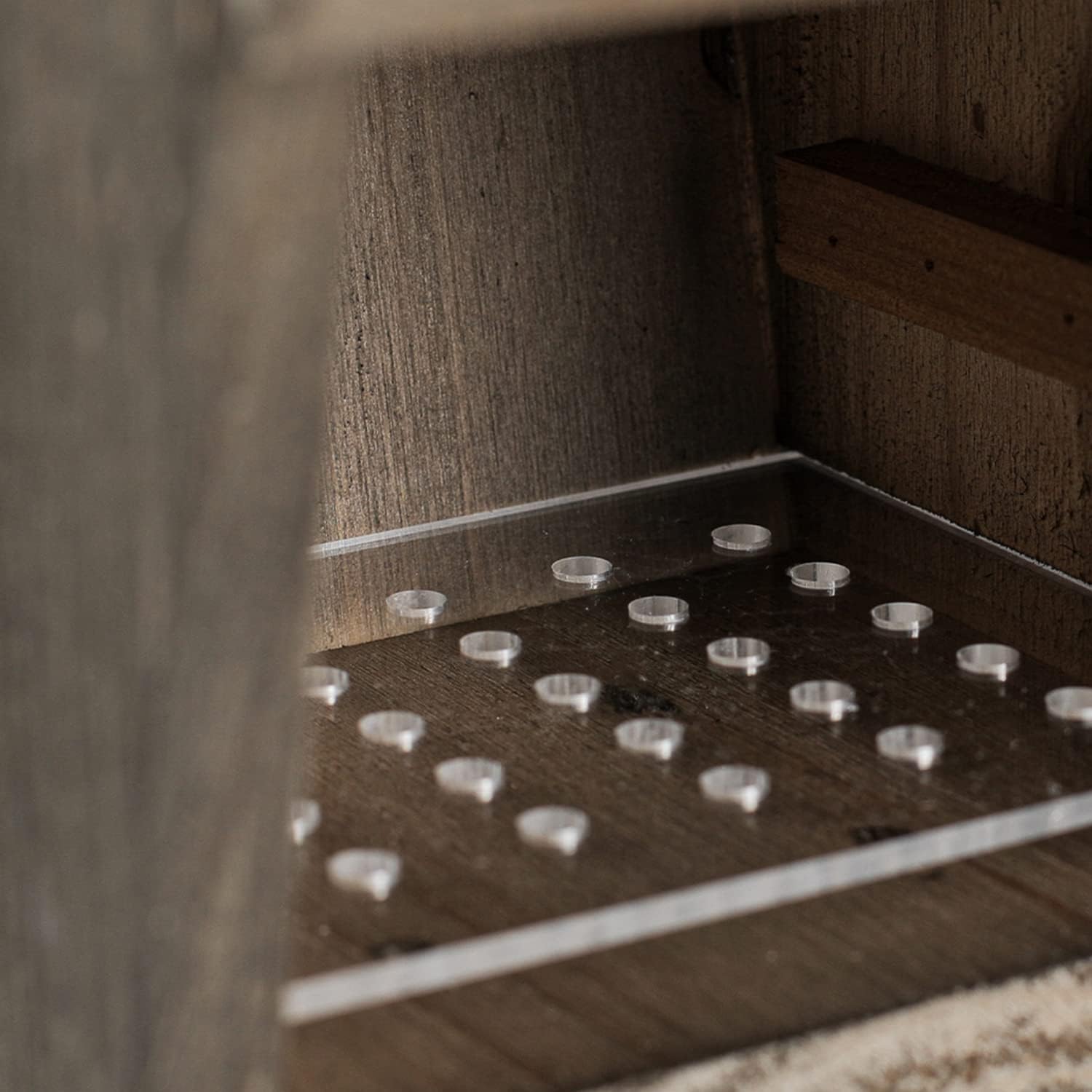 Wooden bird house interior with circular holes on the floor and built-in feeder ledge